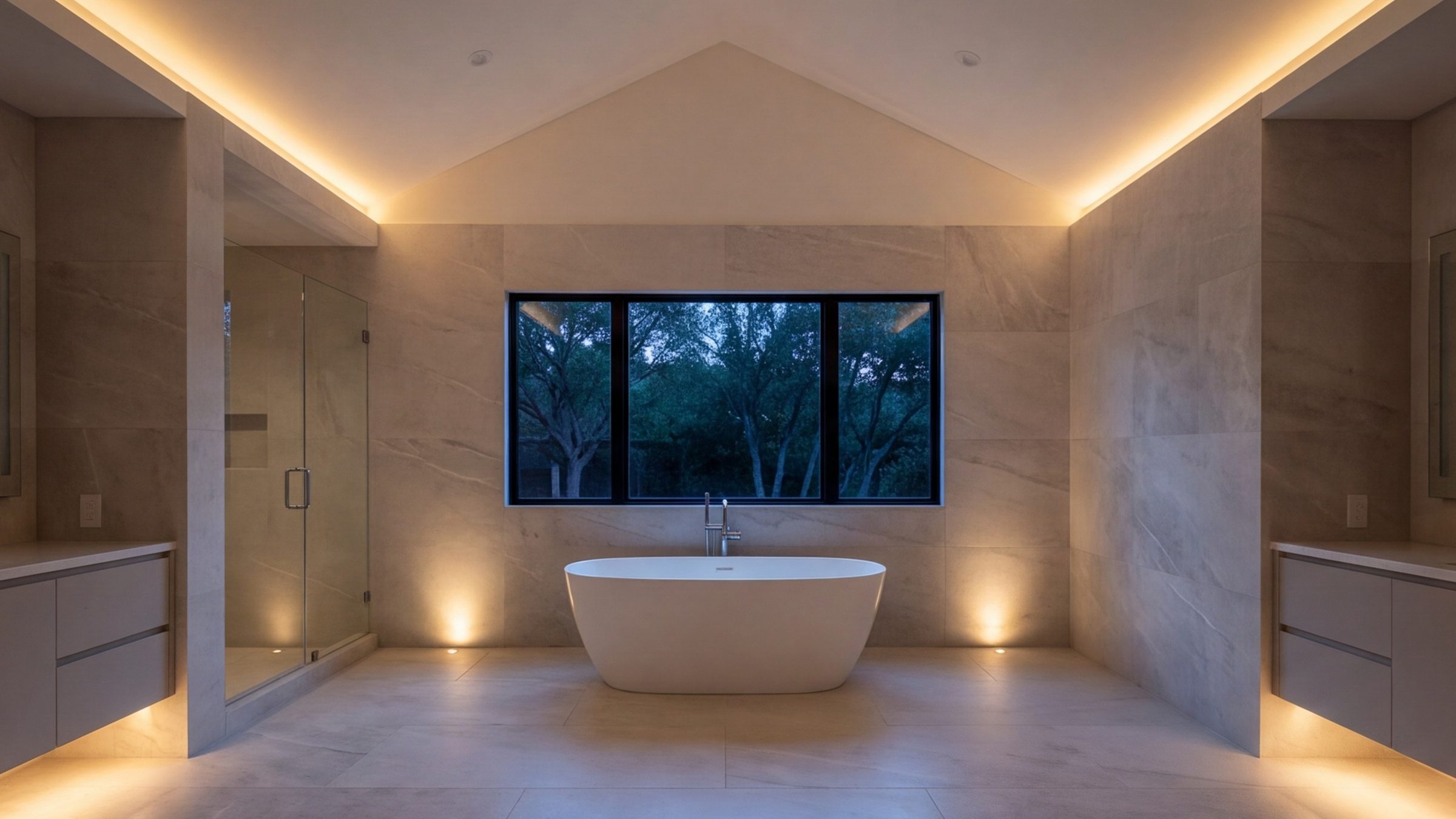 Wide view of a calm primary bathroom with pale stone walls, a freestanding tub and a long window at soft daylight
